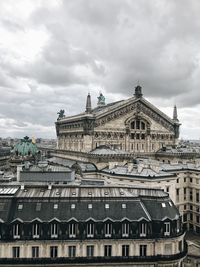 Buildings in city against cloudy sky