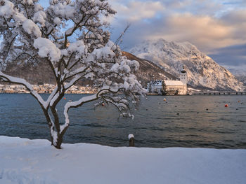 Scenic view of snowcapped mountains by sea against sky