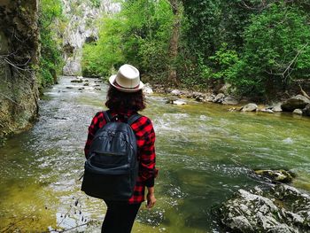 Full length of man standing by river in forest