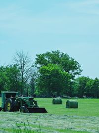 Hay bales on field against clear sky