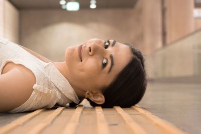 Portrait of young woman lying on floor