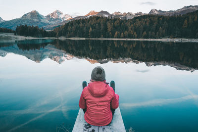 Rear view of woman looking at lake during winter