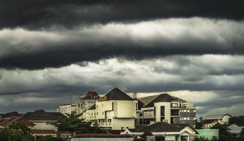 Buildings in city against cloudy sky
