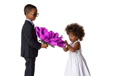 Rear view of a girl holding flower over white background