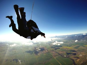 High angle view of person paragliding over mountain against sky