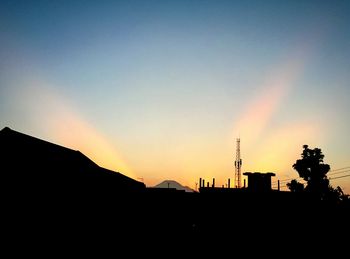 Silhouette of building against sky at sunset