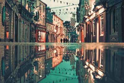 Street shot of architecture reflected in water at shop street i galway city, ireland