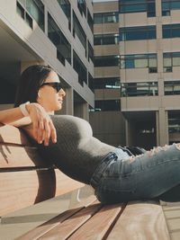 Woman sitting on bench during sunny day