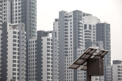 Low angle view of solar panel by buildings in city