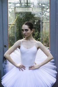 Ballet dancer standing against glass window