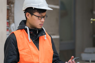 Engineer in reflective clothing using mobile phone