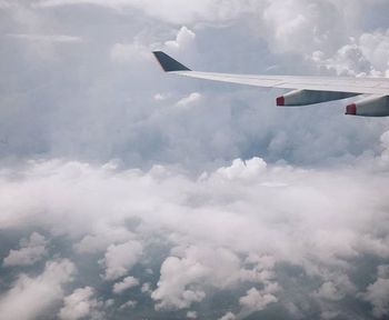 Cropped image of airplane flying over clouds