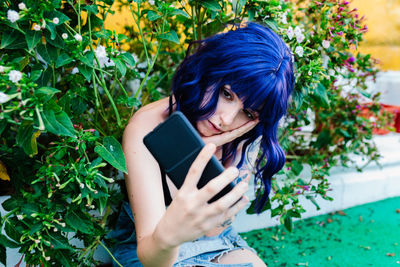 Photo of adorable young woman making selfie outdoors backyard