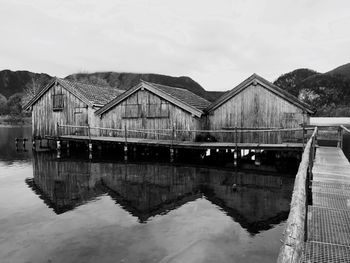 Reflection of houses on lake against sky