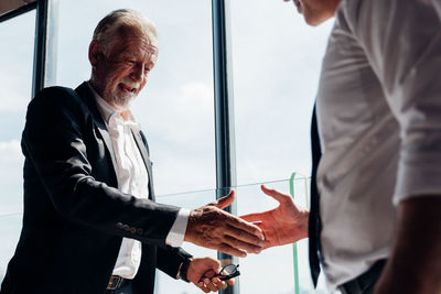 Senior man shaking hand with colleague at office