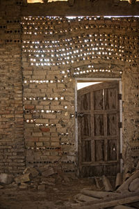 Illuminated lamp on wall of building