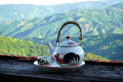 View of tea in cup on table against mountains