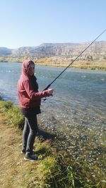 Full length of woman fishing in lake