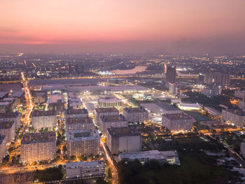 High angle view of illuminated buildings against sky at dusk