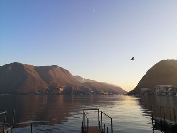 Scenic view of lake and mountains against clear sky