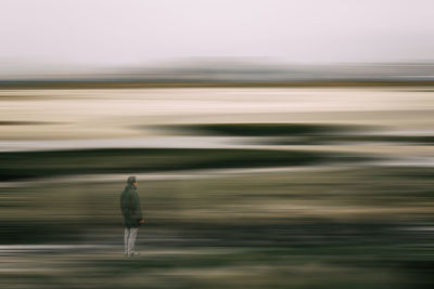 Blurred motion of man walking on road