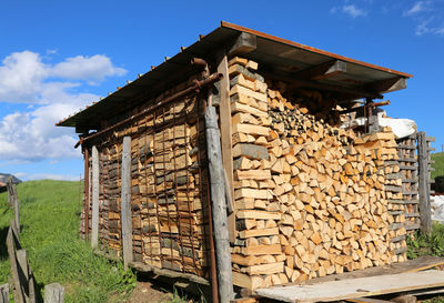 Stack of logs against sky