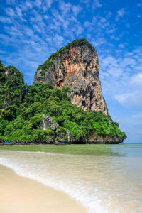 Rock formation on beach against sky