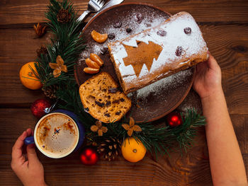 Christmas fruit cake in hand powdered sugar tangerine cranberry fir tree festive decoration stollen