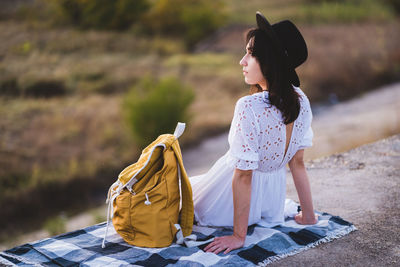 Rear view of woman looking away while sitting outdoors