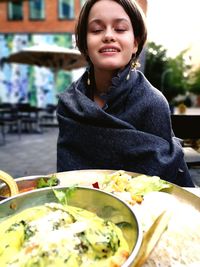 Teenage girl sitting at outdoor restaurant 
