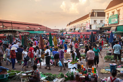 Crowd at market in city against sky