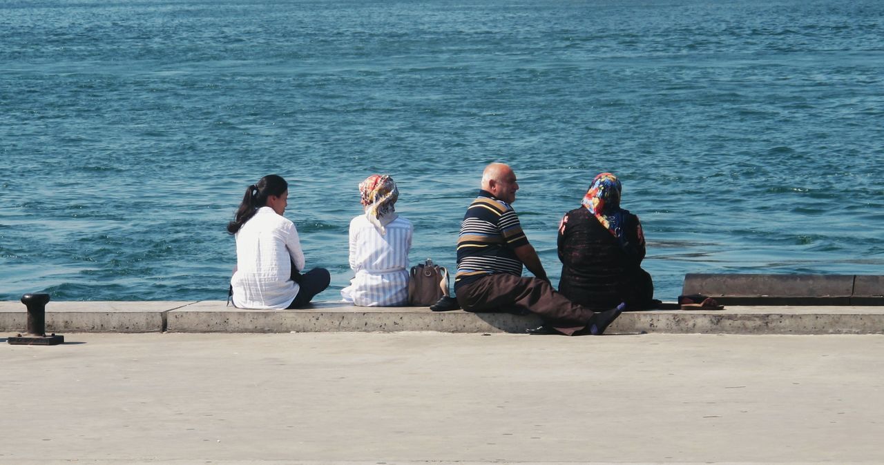 REAR VIEW OF PEOPLE ON BEACH