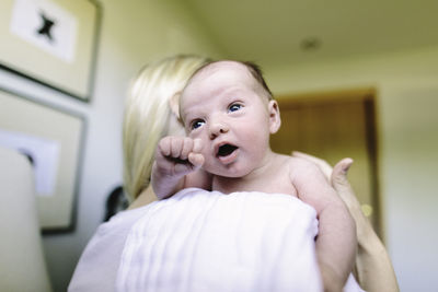 Over the shoulder view of a newborn baby boy in his mother's arms