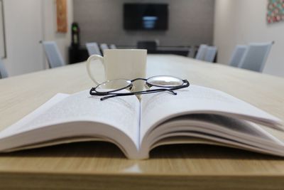 Close-up of open book on table at home