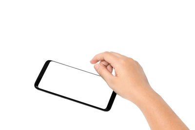 Low section of person holding mobile phone over white background