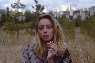 Portrait of beautiful young woman standing on land