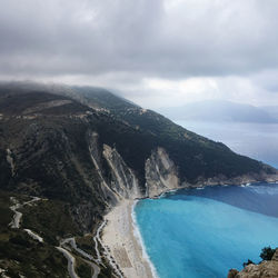 Scenic view of sea and mountains against sky