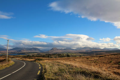 Road passing through landscape against sky