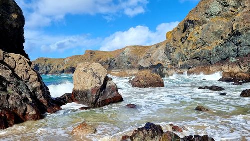 Rocks in sea against sky