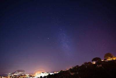 Low angle view of illuminated trees against sky at night