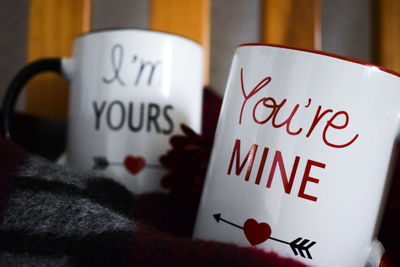 Close-up of mug with texts on blanket