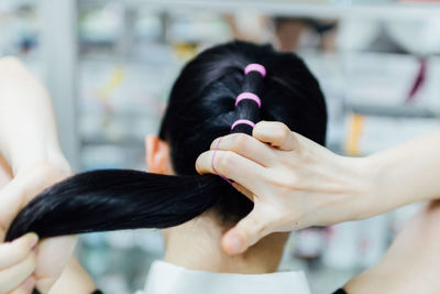 Close-up of woman tying hair