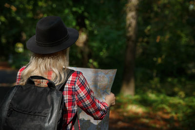 Rear view of woman wearing hat standing outdoors