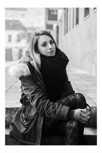 Portrait of young woman with umbrella in park