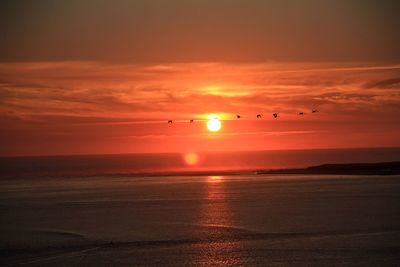 Scenic view of sea against orange sky