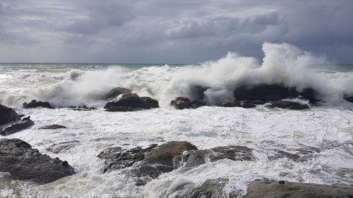 Waves splashing on rocks against sea