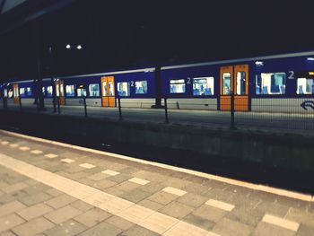 Train at railroad station platform at night