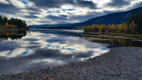 Scenic view of lake by mountains against sky