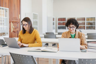Businesswoman using laptop while sitting at desk in office