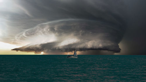 Scenic view of sea against storm clouds during sunset